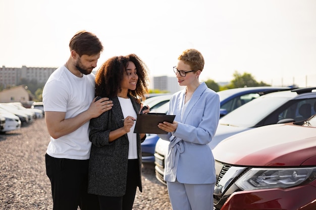 car salesperson assists diverse couple finalizing paperwork dealership symbolizing 161094 28835