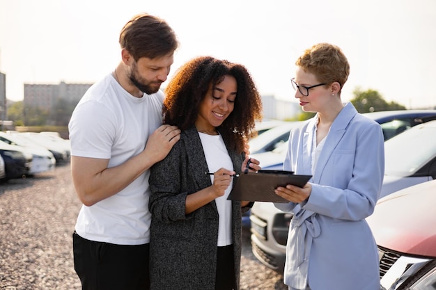 couple signing paperwork with car salesperson dealership finalize vehicle purchase 161094 28819